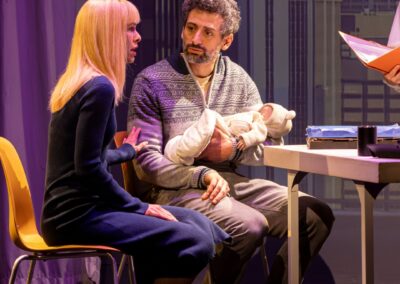 Deux comédiens se font face tenant un bébé